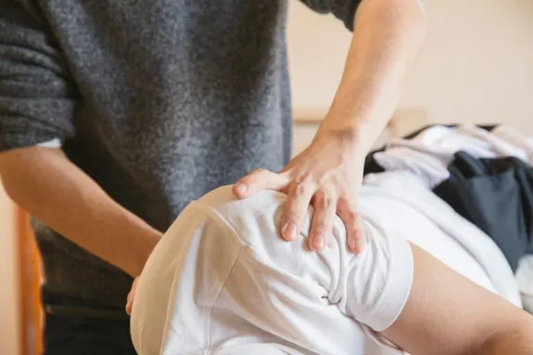 A clinician evaluates a patient's shoulder range of motion during a treatment session. Limitless Spine & Joint Care offers shoulder pain relief in Morganville, NJ.