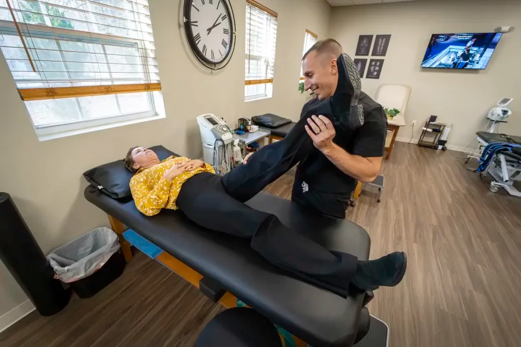 Limitless Healthcare Team at Limitless Spine & Joint Care stretches a patient's leg, addressing potential causes of foot and ankle pain with integrated care.