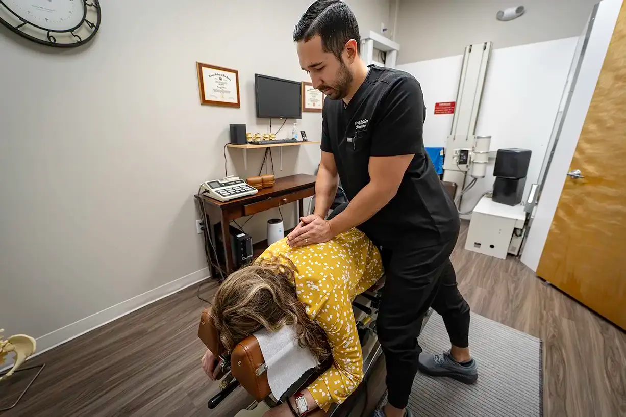A chiropractor at Limitless Spine & Joint Care adjusts a patient lying on a treatment table in a modern office — sciatica treatment in Morganville, NJ.